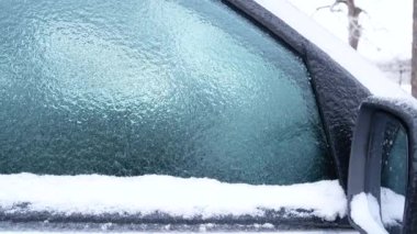 Arabanın camlarında buz var. Araba buz ve karla kaplı. Buz kaldırılana kadar araba kullanılamaz. Kış hazırlığı, arabanın güvenliği ve kullanımı için önemlidir..