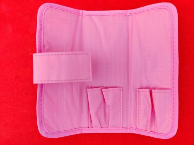 Pembe renk manikür araçları kesesi kırmızı arkaplanda izole.