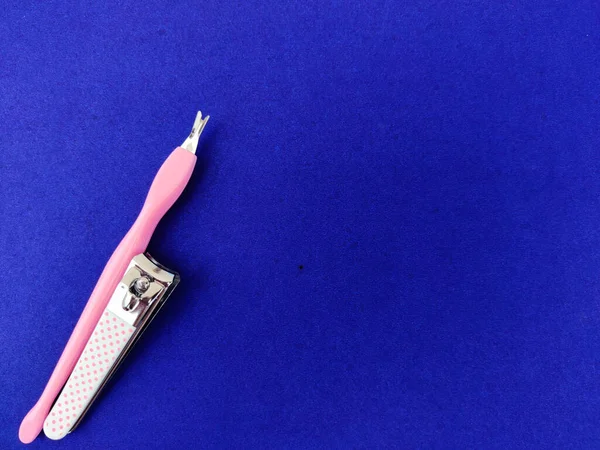 Egy Rózsaszín Körömvágó Manikűr Eszköz Elszigetelt Kék Háttér Másolótér — Stock Fotó