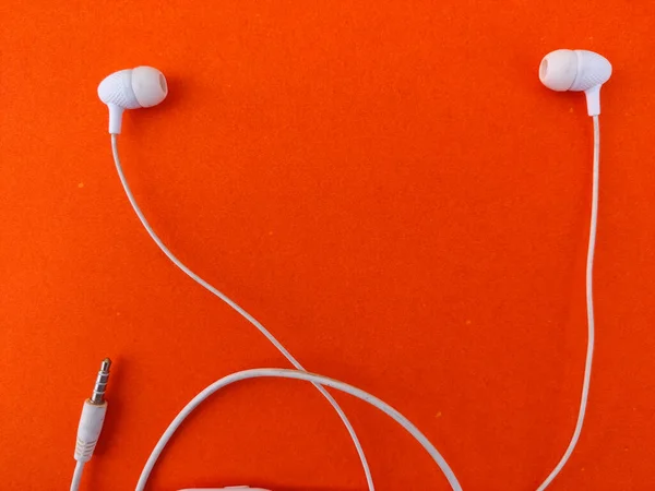 Copie Espacio Entre Dos Audífonos Blancos Aislados Sobre Fondo Naranja —  Fotos de Stock