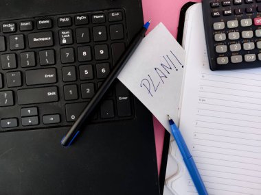 Günlük, dizüstü bilgisayar, iki kalem, hesap makinesi ve 