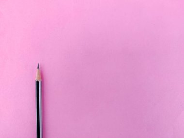 Keskin uçlu, pembe arkaplanda izole edilmiş siyah renkli bir kalemin boşluğunu kopyala