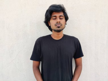 Uzun saçlar, temiz tıraşlı, gözleri kapalı genç bir adam ya da yoga yapıyor. Beyaz arkaplan