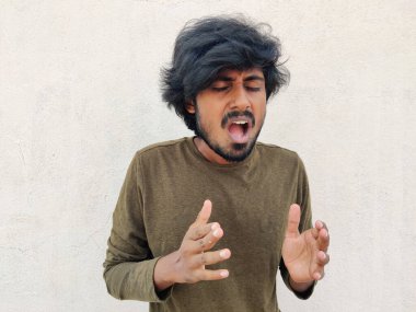 Güney Hintli genç adam hapşırıyor elleri beyaz arka planda soyutlanmış.