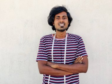 Boynunda mezuralarla gülümseyen erkek terzi. Kolları bağlı duruyor. Beyaz arkaplan