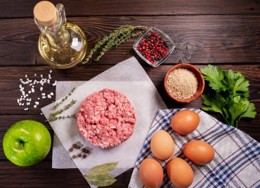 Kıymalı et. Tavuk yumurtası. Ev yapımı mutfak. Ahşap arka planda yemek pişirmek için gerekli malzemelerle birlikte kıyma. Hamburger için malzemeler. Üst görünüm