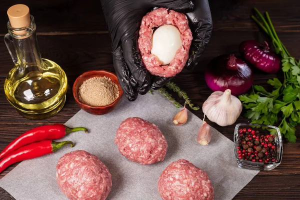 Scotch eggs. Soft boiled eggs with runny yolk wrapped in minced meat. Served with spiced green on a wood tray, view from above. Flat lay