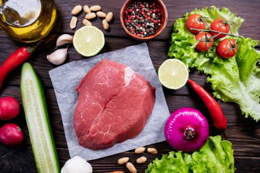 Domatesli ve sebzeli biftek. Ev yapımı mutfak. Ahşap arka planda organik yiyecekler. Üst görünüm