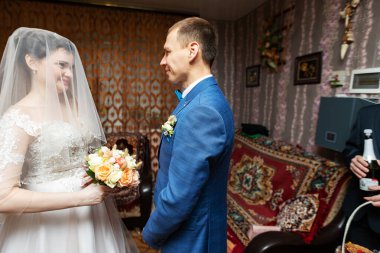 Genç bir gelin, yeni evlilerin zarif aşıklarıyla evlenmeden önce ev içindeki damadı öper ve ona sarılır.