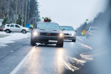 Araba tehlikeli bir şekilde karla kaplı bir otoyolda, kötü hava koşulları ve kaygan asfalt dikkatli sürüş ve düşük hız gerektirir.