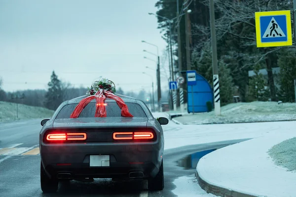 the car is driving dangerously on a winter snow-covered highway, bad weather conditions and slippery asphalt require careful driving and low speed for safety