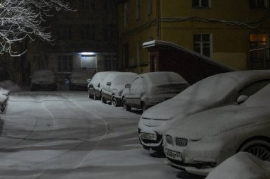 cars in the parking lot were covered with snow, problems for car owners due to a heavy snowstorm, winter snowdrifts in the city clipart