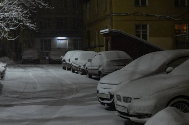 Otoparktaki arabalar karla kaplıydı. Şiddetli kar fırtınası nedeniyle araba sahipleri için sorunlar vardı. Şehirde kar yağışı vardı.