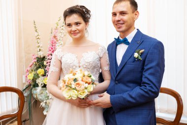 Yeni evliler evlilik belgesini imzalarlar, aşıklar evlilik sözleşmesini doldurur, aile hukuki evraklarını düğünde doldururlar.