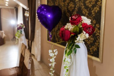 Düğünde çiçekli süslemeler, restoranın iç dekorasyonu bayram için dekoratör tarafından hazırlandı, masadaki vazolarda güzel taze çiçekler, misafirlerin hediyesi olarak bir buket çiçek.