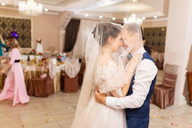 Yeni evlendim, iki aşık düğünde dans ediyor, şık takım elbiseli bir restoranda romantik bir kutlama.