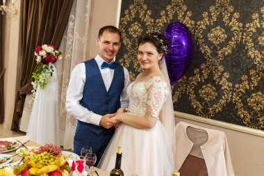 Yeni evliler ellerinde güzel kristal bardaklar, bir düğünde alkol içme geleneği, gelin ve damadın bir restoranda kadeh kaldırması.