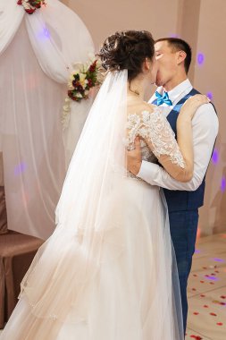 Yeni evlendim, iki aşık düğünde dans ediyor, şık takım elbiseli bir restoranda romantik bir kutlama.