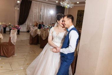 Yeni evlendim, iki aşık düğünde dans ediyor, şık takım elbiseli bir restoranda romantik bir kutlama.