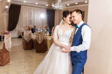 Yeni evlendim, iki aşık düğünde dans ediyor, şık takım elbiseli bir restoranda romantik bir kutlama.