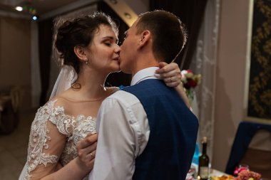 Yeni evlendim, iki aşık düğünde dans ediyor, şık takım elbiseli bir restoranda romantik bir kutlama.