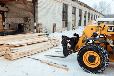Kalaslı forklift kamyonu, depoya ahşap teslimatı endüstriyel taşımacılığın yardımıyla çok sayıda ahşap kalas yüklemesi.