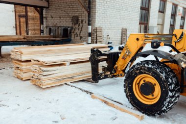 Kalaslı forklift kamyonu, depoya ahşap teslimatı endüstriyel taşımacılığın yardımıyla çok sayıda ahşap kalas yüklemesi.