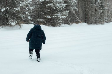 Zorlukla yürüyen bir adam, yoğun bir kar yağışı sonrası kaldırımda kar yağışı yapar. Kışın kamu hizmetlerinin kötü işleyişi