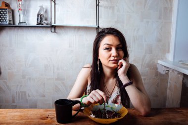 Kız masada oturmuş tatlı bir tatlı yiyor. yüksek kalorili kahvaltı