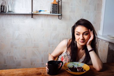 Kız masada oturmuş tatlı bir tatlı yiyor. yüksek kalorili kahvaltı