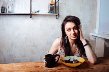 Kız masada oturmuş tatlı bir tatlı yiyor. yüksek kalorili kahvaltı