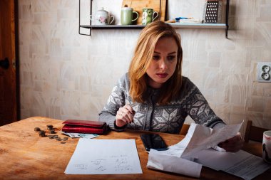 Gelir düşüşü ve finansal kriz. Yüksek daire ve elektrik faturaları. Yorgun kız vergi beyannamelerini dolduruyor
