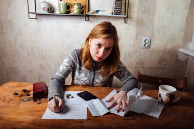 Kız vergileri sayıyor. Faturalar ve kira için ödeme belgelerini doldurun. Ailede uygun para dağılımı