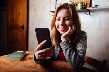 Kız telefonda konuşurken gülüyor.