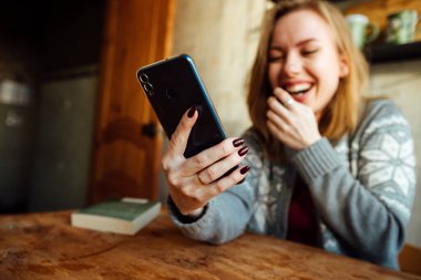 Kız telefonda konuşurken gülüyor.