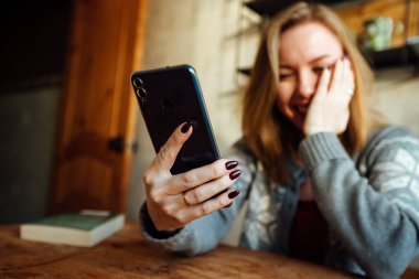 Kız telefonda konuşurken gülüyor.