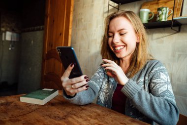 Kız telefonda konuşurken gülüyor.