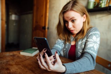 Şaşırmış kız telefondaki müfettişi dinliyor, eliyle başını tutuyor.