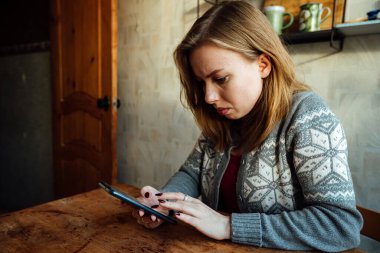 Şaşırmış kız telefondaki müfettişi dinliyor, eliyle başını tutuyor.