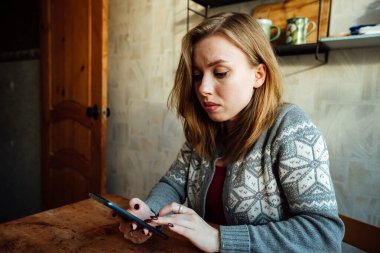 Şaşırmış kız telefondaki müfettişi dinliyor, eliyle başını tutuyor.