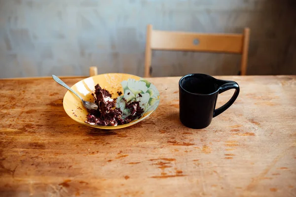 half-eaten cake and coffee on the table. the man left his breakfast