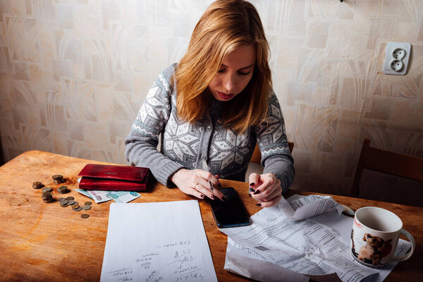 падение доходов и финансовый кризис. высокие счета за квартиру и коммунальные услуги. уставшая девушка заполняет налоговые декларации