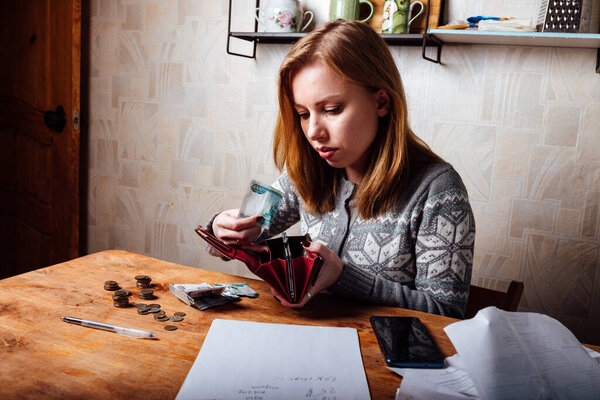 падение доходов и финансовый кризис. высокие счета за квартиру и коммунальные услуги. уставшая девушка заполняет налоговые декларации