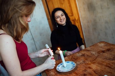 Bir kız geleceği görmek için falcıya mum yakar.