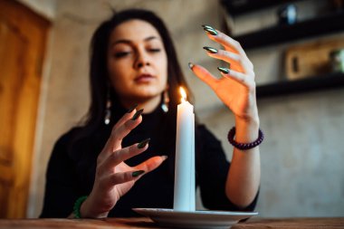 Kız, yanan bir mum ve kartlarla geleceği ve kaderi tahmin ediyor.