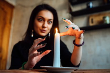 Kız, yanan bir mum ve kartlarla geleceği ve kaderi tahmin ediyor.