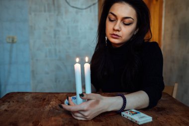 Falcı, bir mum alevine bakar. Geleceği görmek için büyülü bir ayin.