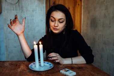 Falcı, bir mum alevine bakar. Geleceği görmek için büyülü bir ayin.