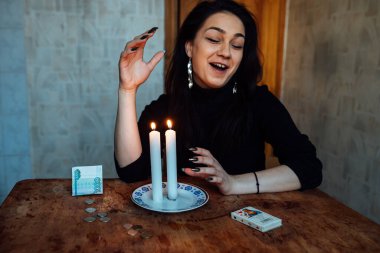 Falcı, bir mum alevine bakar. Geleceği görmek için büyülü bir ayin.