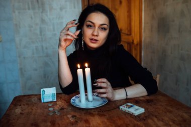 Falcı, bir mum alevine bakar. Geleceği görmek için büyülü bir ayin.